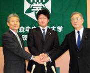 握手する左から、青森中央学院大野球部の白川総監督、明戸監督、小倉部長
