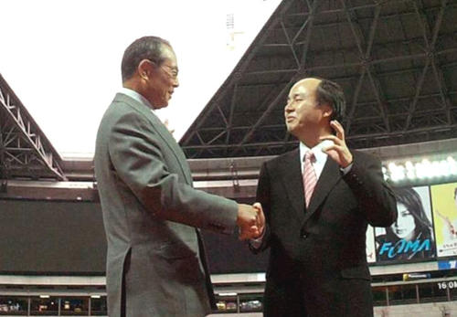 04年12月、福岡ドームで王監督（左）と握手する孫社長