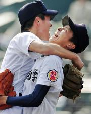 優勝を決め高甫三塁手（左）と抱き合う沖縄尚学の東浜投手（共同）
