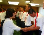 高橋知事(左)から握手で激励を受ける駒大岩見沢の板木
