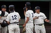 試合中、ベンチ前で手ぶりを交えて選手に指示を出す佐藤監督（右端）