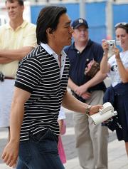 ２３日、クッションのようなものを手に球場入りする松井