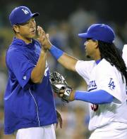 6勝目をマークした黒田(左)はラミレスとハイタッチ(共同)