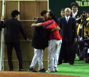 表彰式のボード裏ででラミレス（右）と喜び合う岡島（撮影・野上伸悟）