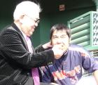 野村元監督(左)にひげをそったご褒美でチョコを食べさせてもらう畠山