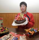 バレンタインデーのチョコレートケーキを持ち、笑顔の堂林（撮影・菊川光一）