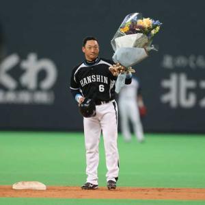 ５回表阪神２死一、三塁、１５００打点を決めた金本は花束を手にする（撮影・井上学）