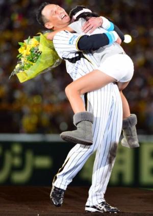 娘からの花束贈呈で抱きつかれ笑顔を見せる金本（撮影・清水貴仁）