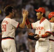 試合に勝ち永川勝浩と栗原健太はハイタッチを交わす(撮影・倉掛優一)