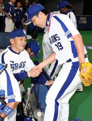 吉見（右）を出迎えて握手を交わす落合監督（撮影・清水貴仁）