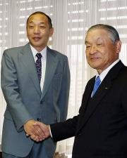 落合監督(左)は白井文吾オーナーと握手を交わす(撮影・清水貴仁)