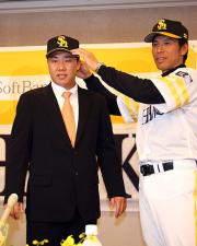 入団会見で秋山監督から帽子をかぶせてもらう李机浩(撮影・藤尾明華)