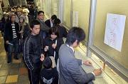 チケットの払い戻しを求めて長い行列をつくるファン