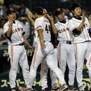 阪神戦に勝ち越し、大道(44)らナインを迎える原監督(左)