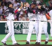 守り切った荻野（右）と喜びのハイタッチ交わすオーティズ（中央）、塀内