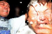 細川（左）にビールをかけられ、くもんの表情を浮かべる大久保コーチ