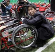 寄贈する車いすにサインする赤星（撮影・宮崎幸一）