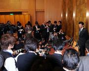 報道陣に囲まれ会見する三浦。奥にある金びょうぶの前での会見は拒否