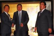 楽天三村編成部長(左)と握手する中村紀。右は米田球団代表
