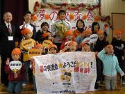 母校を訪れた東野(中央)は小学生との記念撮影で笑顔を見せる