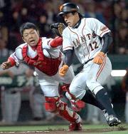 小笠原の左前打で二塁走者の鈴木（右）は本塁を狙うがタッチアウト