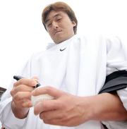 ４勝目を挙げた石井一は試合後ボールにサインする（撮影・水谷安孝）