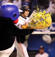７回、通算２００号本塁打を放った阿部は、つば九郎から花束を受け取る