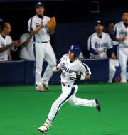 7回裏、試合を決める中前適時打を放った荒木。ベンチ前では吉見が拍手