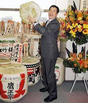 日本一に輝いた原監督はお祝いのたる酒を持ち上げ、笑顔を見せた