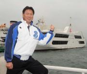 会見を終えた尾花監督はマリーンルージュ号をバックにガッツポーズ
