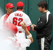 ブルペン投球を終えた今井(背中)に握りを指導する野茂臨時コーチ(右)