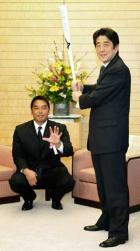 巨人の阿部主将(後方)と、贈られたバットを構える安倍首相(共同)