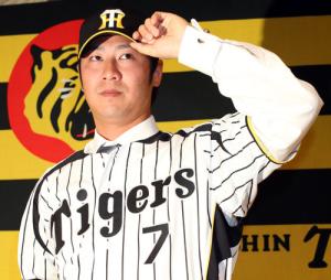 阪神入団発表で背番号7のユニホームに袖を通した西岡剛(撮影・田崎高広)