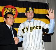 入団会見で阪神沼沢本部長（左）と握手するリーソップ（撮影・河南真一）