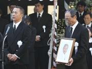 兄鉄城さんの遺影を手に弔辞を聞くソフトＢ王最高顧問（右）