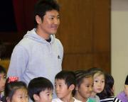 母校の体育館で１年生生徒と記念写真に納まる高橋尚成（撮影・沢野健太）