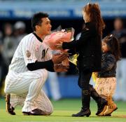 愛娘の芽依ちゃん(手前)と花菜ちゃんから花束を贈られ、涙ぐむ黒木(撮影・栗山尚久)