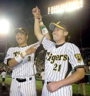 岩田(右)は、関本に腕を上げられ笑顔を見せる(撮影・宮崎幸一)