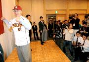 ユニホームを着たブラウン新監督は報道陣に向かってガッツポーズする