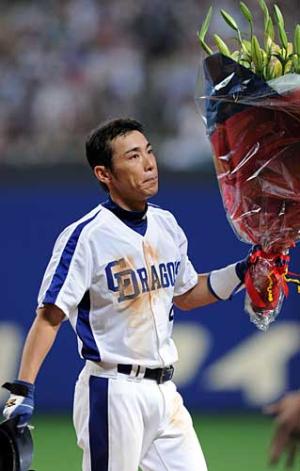 通算１５００本安打を達成した荒木は、花束を手にファンの歓声に応える