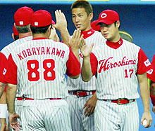 6回を無失点で6勝目を挙げた広島大竹(右)はナインとタッチ(共同)