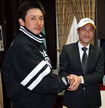 車いすの寄贈で宮崎県庁を訪れた川崎（左）は東国原知事と握手を交わす（撮影・進尚幸）
