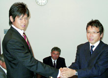 指名あいさつに訪れた阪神の沼沢本部長（右）と握手する白仁田投手（共同）