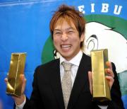 中島は金塊に見立てたおもちゃを手に笑顔