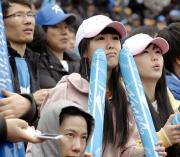 ソウル市内の球場で１０回の韓国の攻撃を不安そうに見守る人たち（共同）