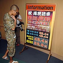 会見後、視聴率が記されたボードに見入る亀田