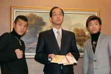 夕張市中島助役（中央）に義援金を渡した亀田興毅（左）と大毅