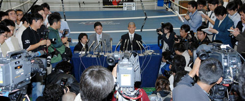 報道陣に囲まれ謝罪会見に臨む協栄ジムの金平桂一郎会長(中央左)と亀田興毅