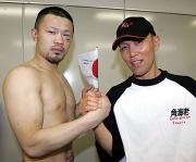 握手を交わす小堀(左)と田中トレーナー