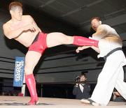 小笠原和彦（右）にキックを見舞う高野忍（撮影・宮崎幸一）